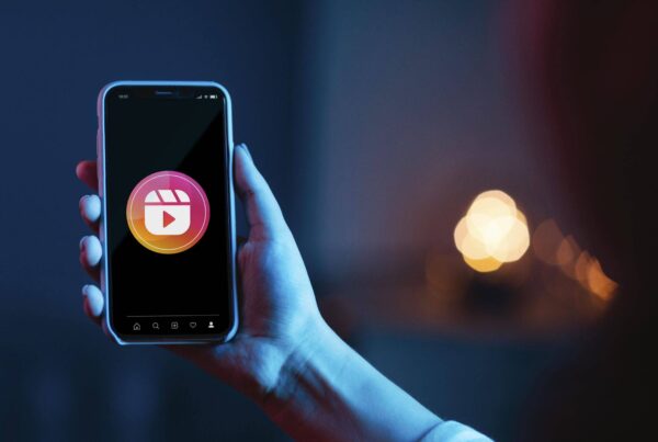Smartphone affichant un Reel Instagram avec interactions visibles, illustrant une stratégie de marketing digital pour augmenter la visibilité et l’engagement.
