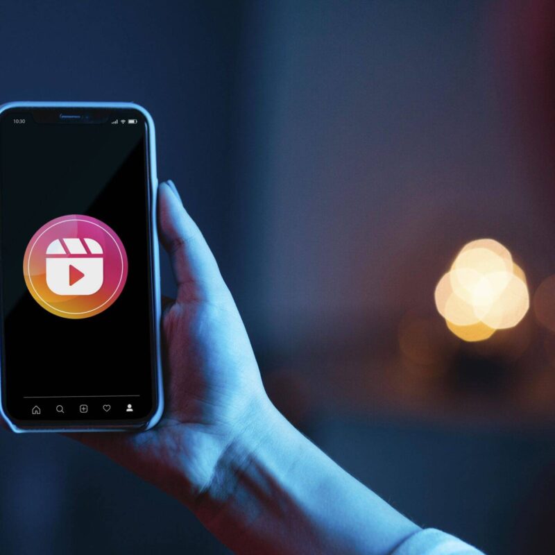 Smartphone affichant un Reel Instagram avec interactions visibles, illustrant une stratégie de marketing digital pour augmenter la visibilité et l’engagement.
